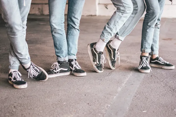 Beine von Menschen in Jeans uns Sneakers - Foto von Ben Weber